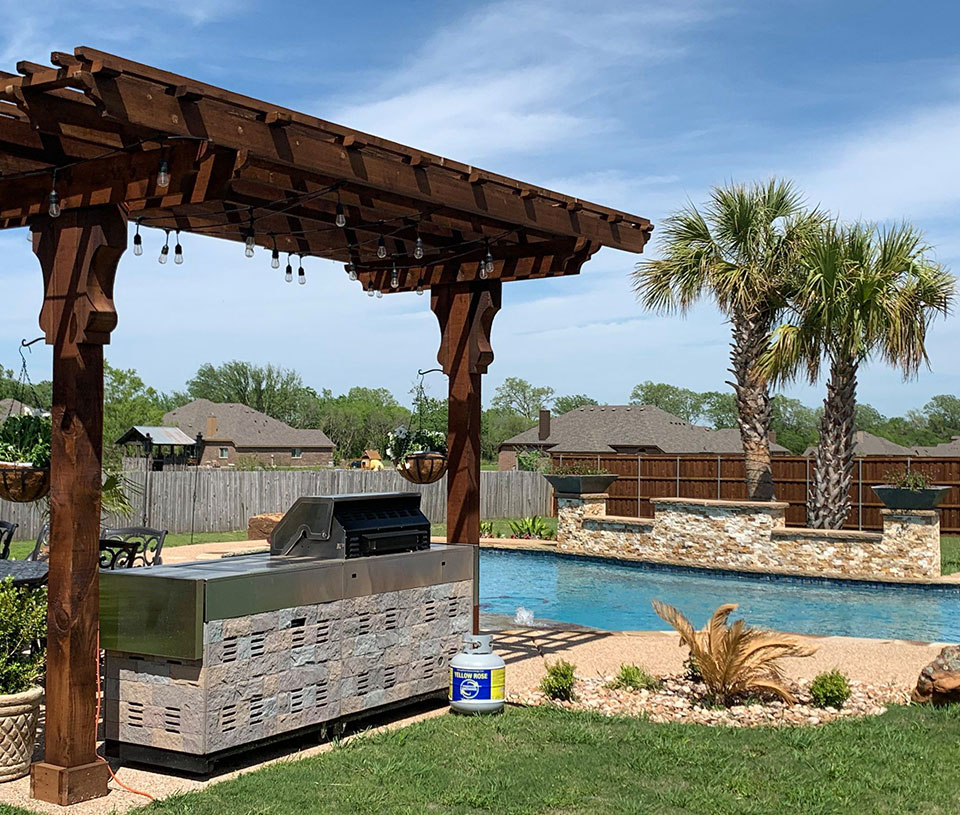 Outdoor kitchen with a pool in the sunlight in Ovilla 